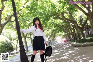 A woman in a school uniform is posing for a picture.