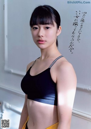 A woman in a pink sweater and panties posing for a picture.