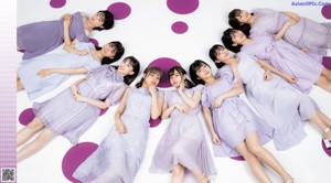 A group of young women sitting on top of a bed.