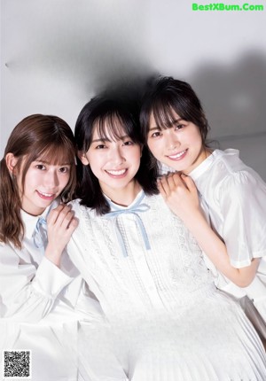 A group of three women sitting on the ground.