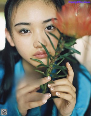 A woman in a white jacket and shorts posing for a magazine.