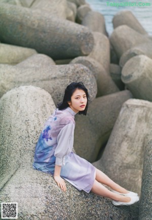 A woman with long black hair is posing for a magazine.