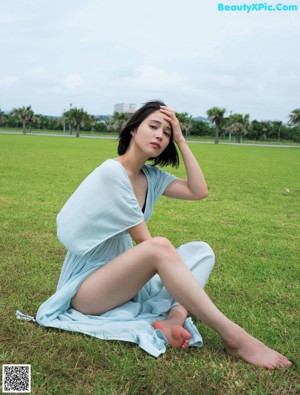 A woman sitting on a swing in a park.