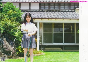 A woman in a school uniform standing in a room.