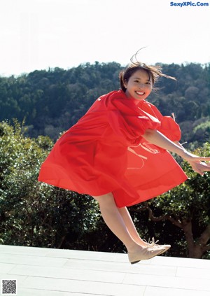 A woman in a red dress is posing for a picture.