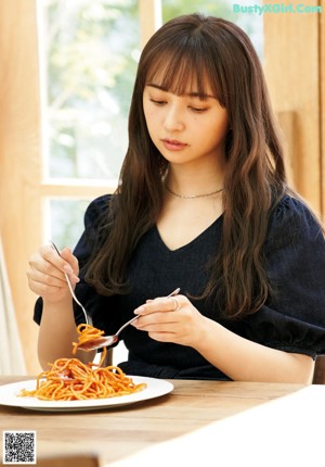 A woman holding a cup of coffee and a plate of food.
