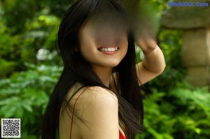 A woman in a red bodysuit posing for a picture.