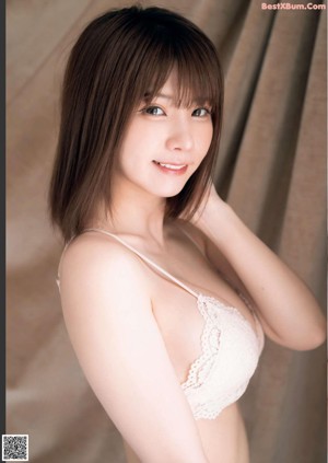 A woman in a white lingerie posing in front of a mirror.