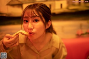 A woman holding up a menu in front of her face.