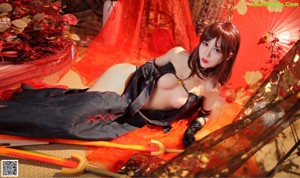 A woman in a black and red outfit holding a sword.