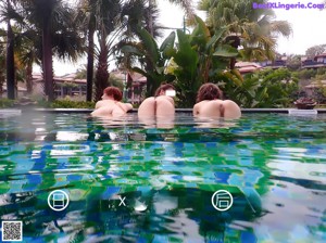 A group of women standing next to each other in a pool.